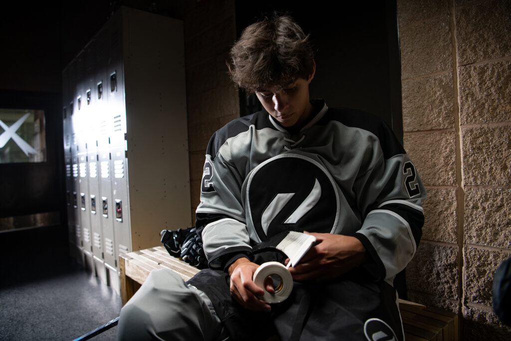 Boy taping hockey stick